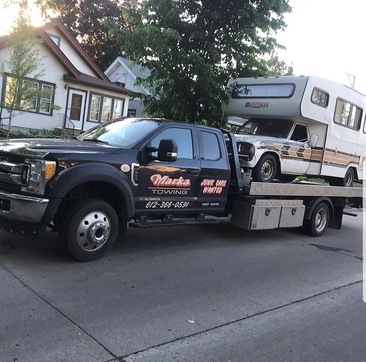 Marka Towing black flatbed with RV